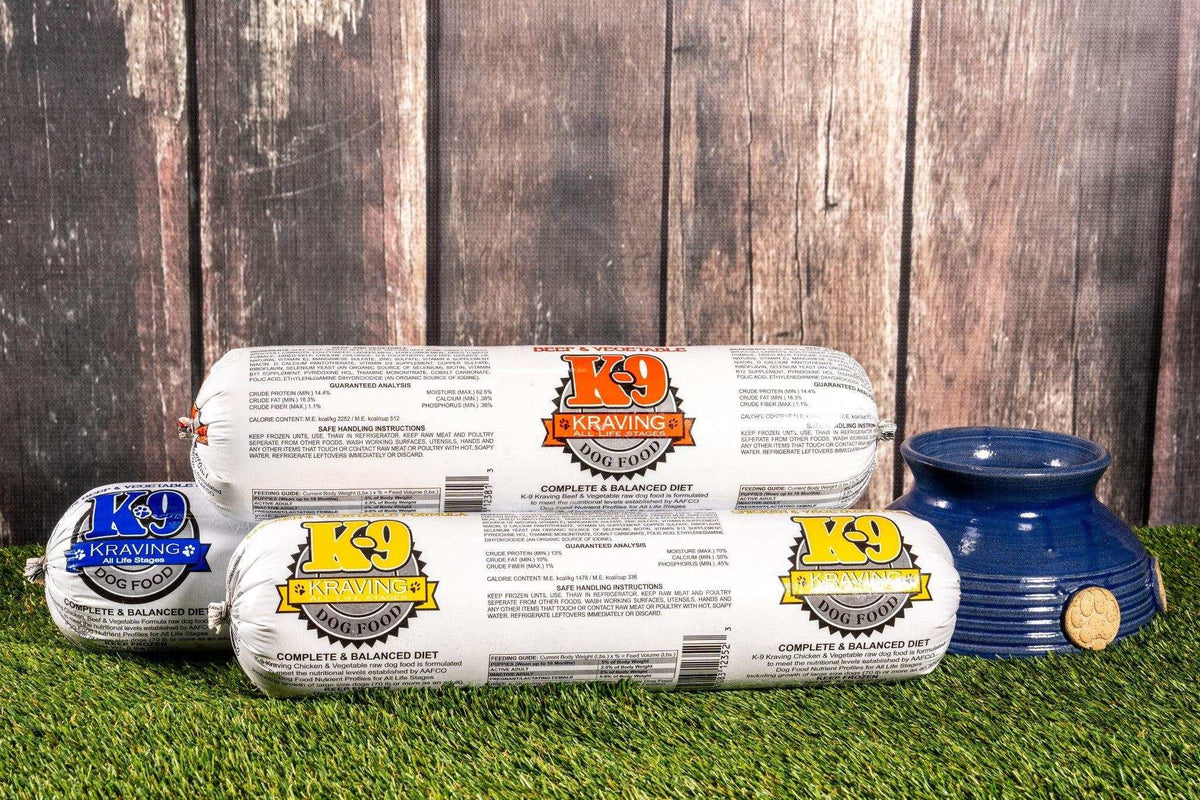 Raw Dog Food rolls in white packaging with colorful K9 Kraving labels, displayed beside a blue pet bowl.