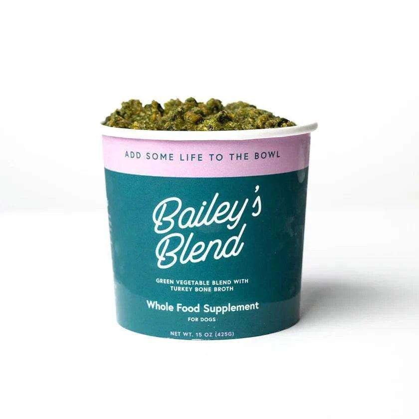 Frozen vegetable blend, Bailey’s Blend in a teal tub with a pink band and chunky green vegetables visible on top.