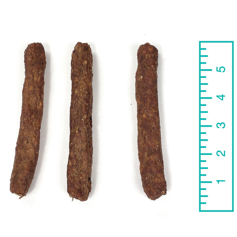 Three 5-inch Bully Snaps beef chew sticks next to a ruler showing their length