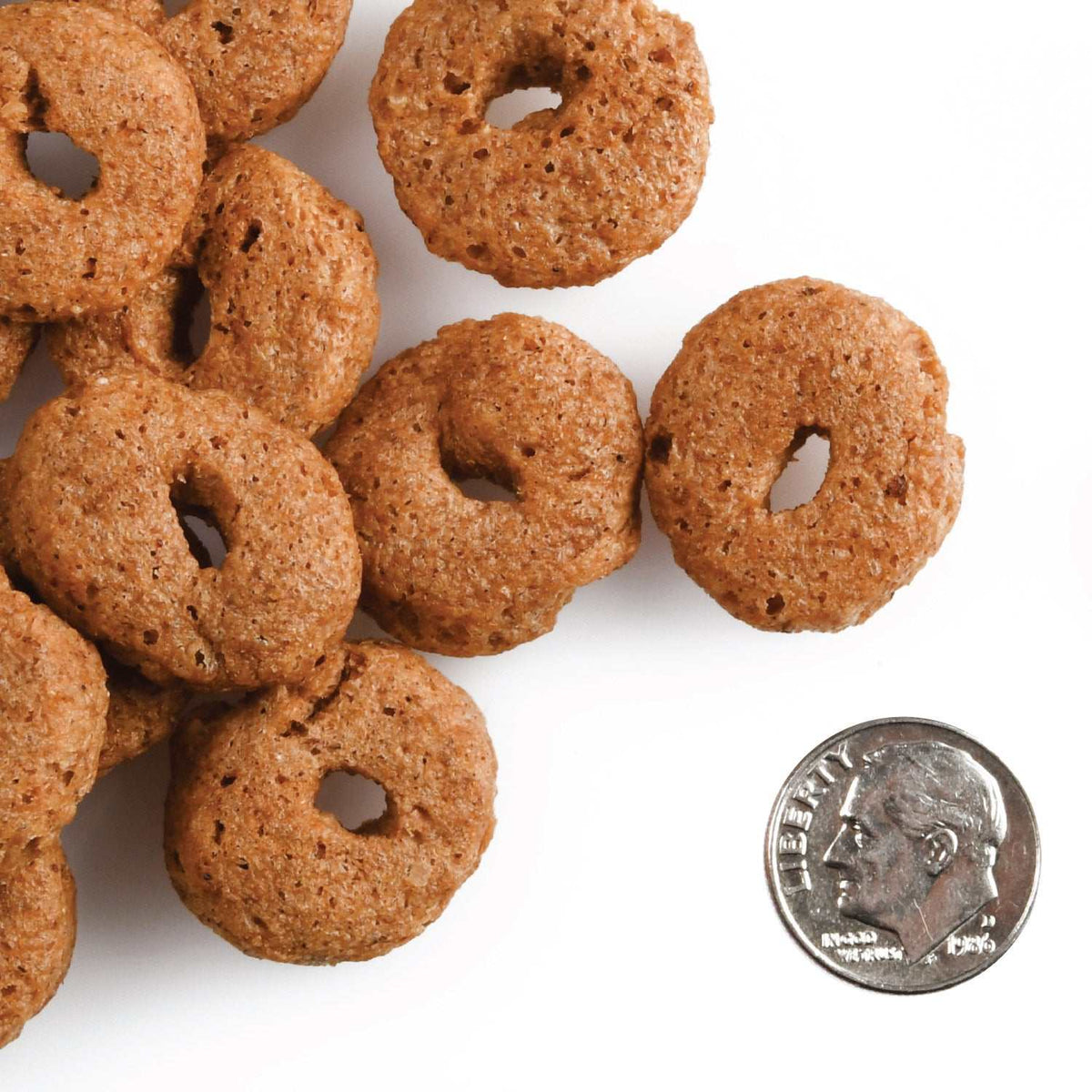 CRUNCH O's Bacon Blasters dog treats next to a dime for size comparison.