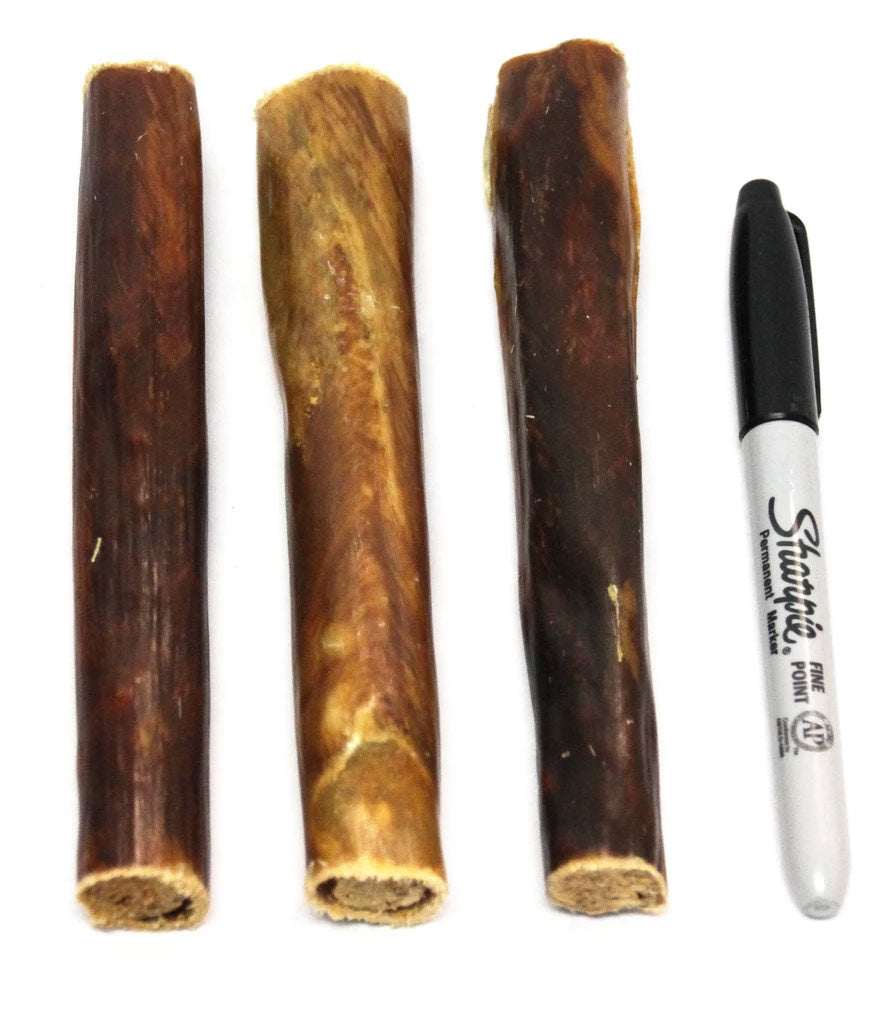 Three Chewy Bulls dog treats made from beef esophagus next to a black Sharpie marker for size comparison