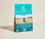 Puppy kibble bag in teal and brown with a dog image, labeled Ancient Grains High-Protein Puppy Food featuring chicken and salmon recipe