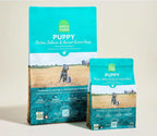 Puppy kibble in turquoise bags featuring chicken, salmon and ancient grains recipe artwork; Ancient Grains High-Protein Puppy Food.