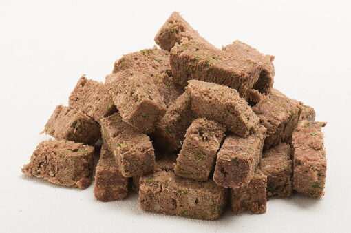 freeze dried beef dog food cubes stacked on white background