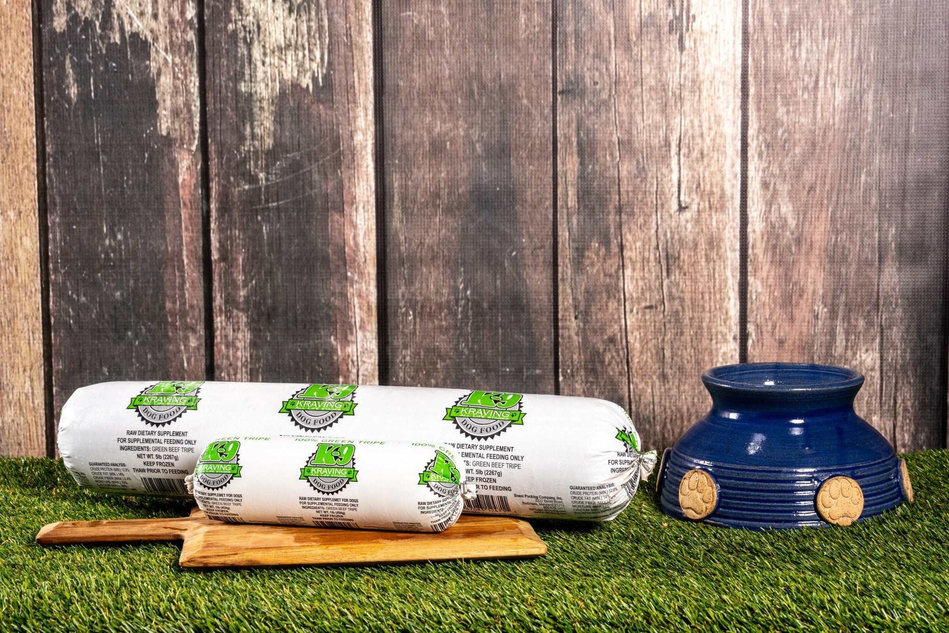 K-9 Kraving Green Tripe raw food supplement for dogs on wooden board and grass.