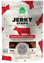 Jerky Strips dog treat pouch in white with red cow illustrations, green logo, and bold grass-fed beef recipe label