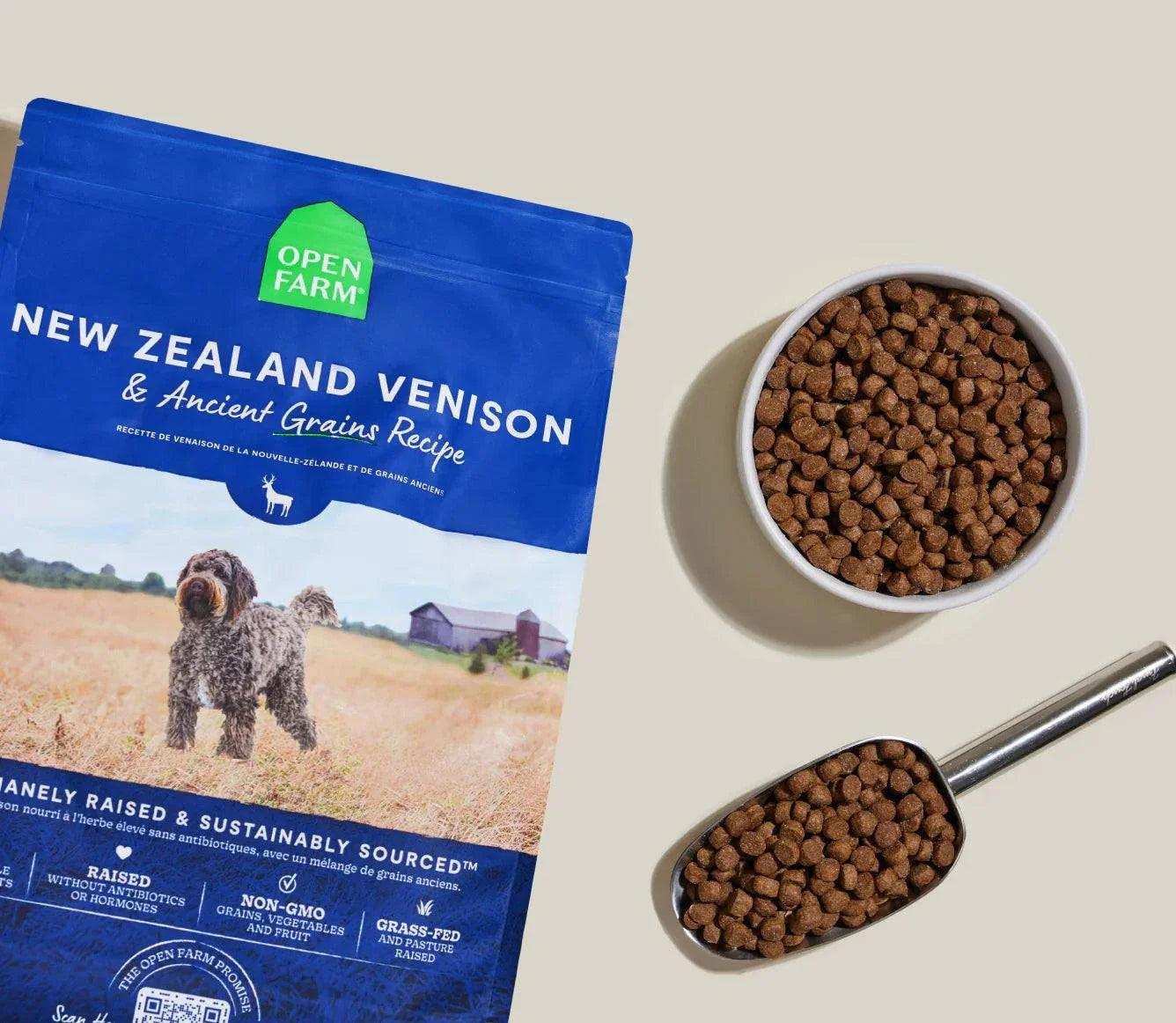 New Zealand Venison & Ancient Grain Recipe dog kibble pack with bowl and scoop of brown dry dog food pellets