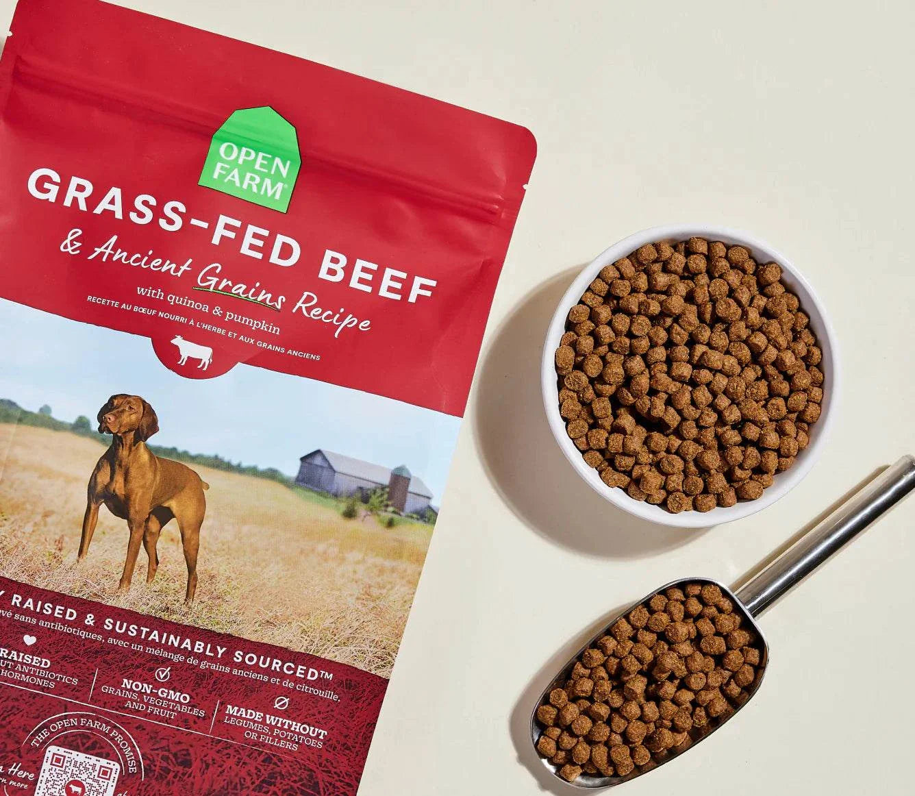 Bag of Open Farm Grass-Fed Beef and Ancient Grains dog kibble with bowl and scoop of kibble.