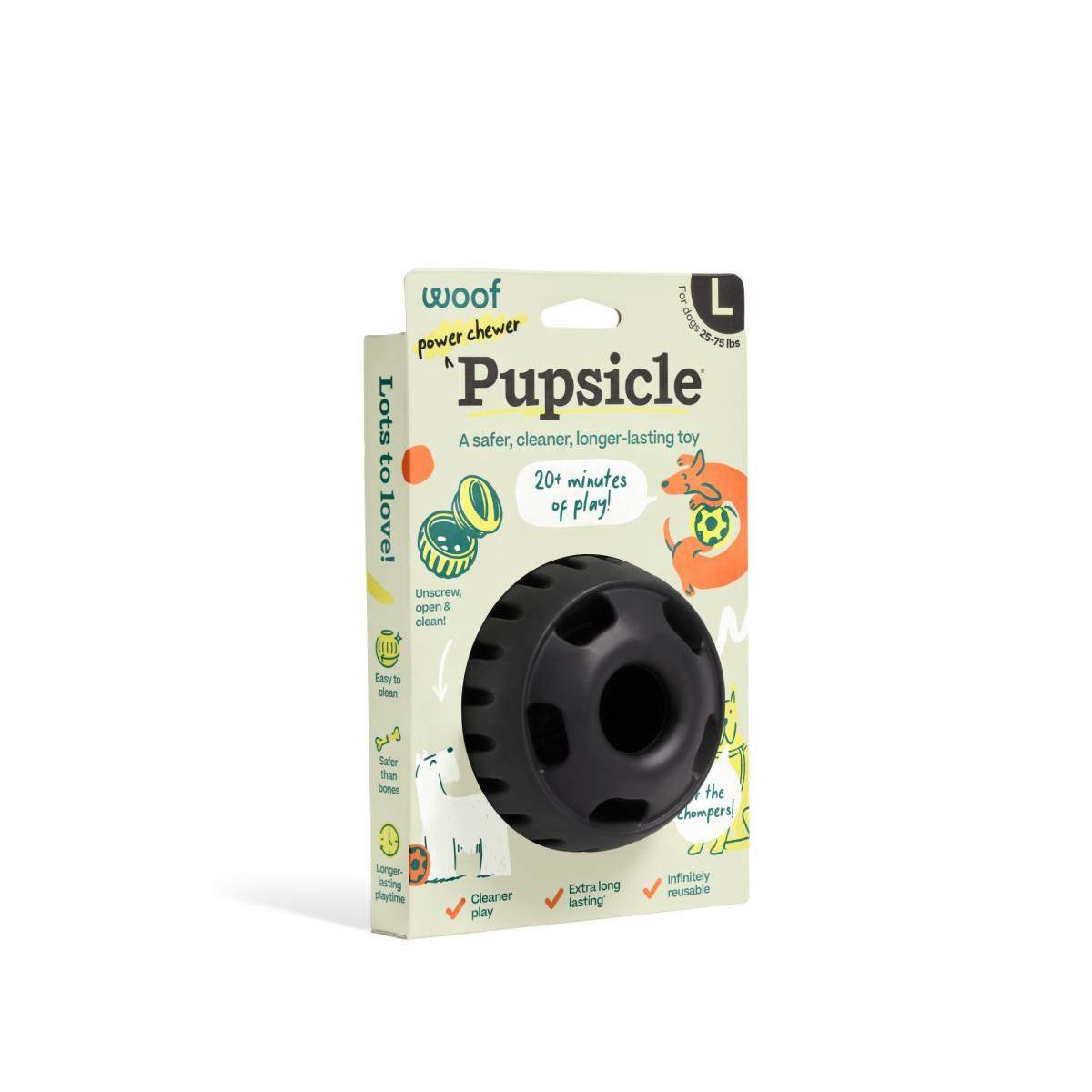 Pupsicle dog enrichment toy with a black, rounded rubber body and central treat opening, packaged in a colorful box.