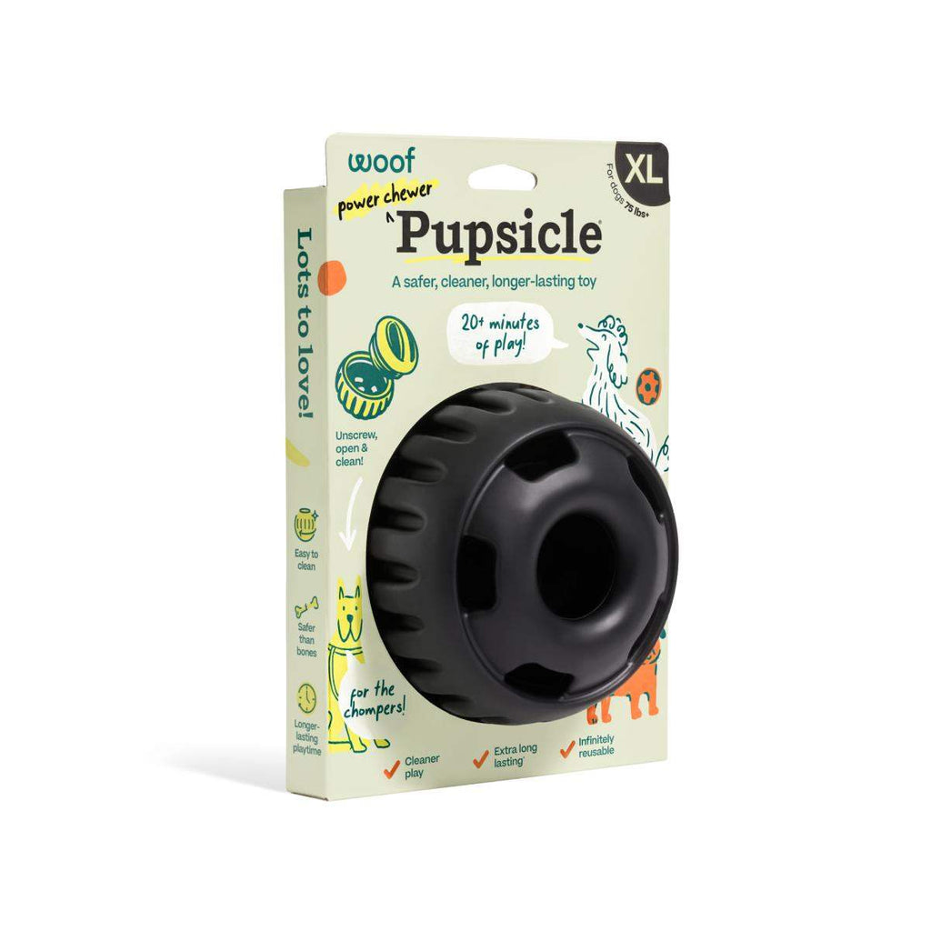 Pupsicle dog enrichment toy in black rubber, round weighted design with a large center opening, shown in XL packaging.