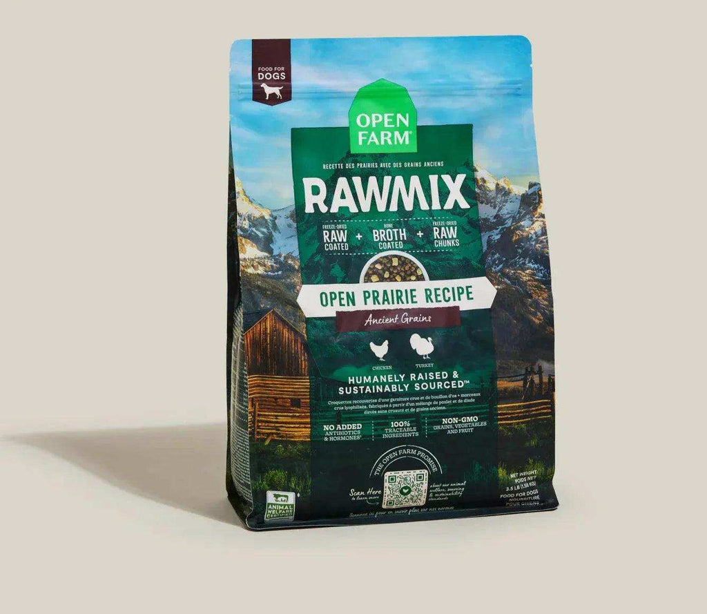Dog kibble in a dark green and blue bag, RawMix Open Prairie recipe with mountain and farm graphics and a resealable top.
