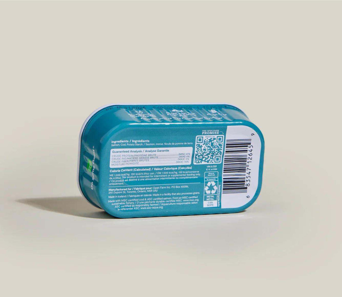 Salmon & Cod Topper dog food in a turquoise plastic tray, with a white barcode label and printed product details.