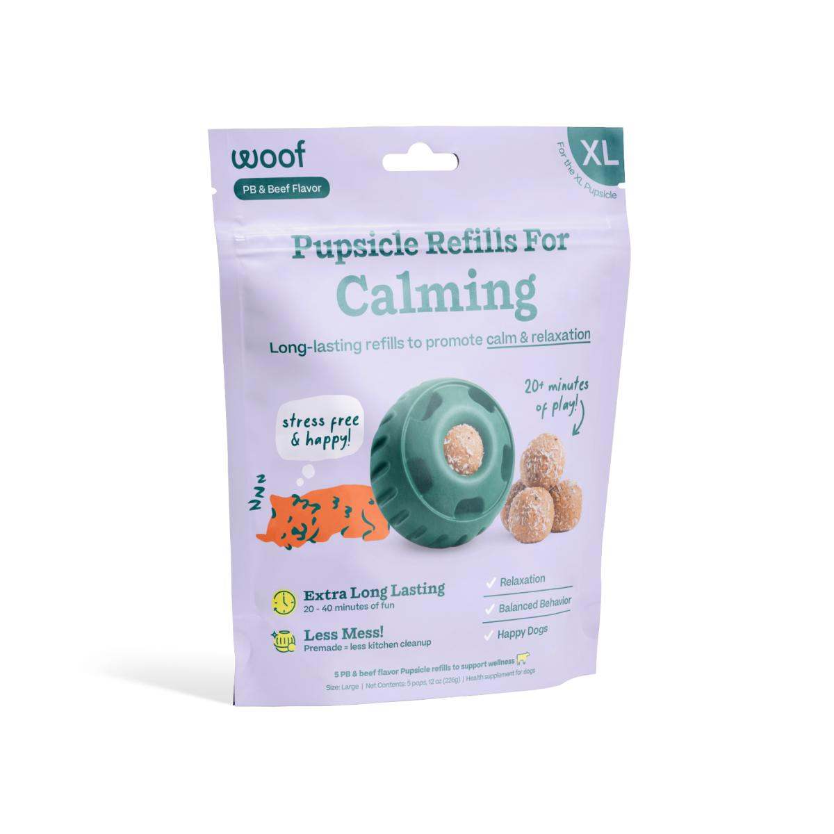 Dog treat refill pack in a lavender pouch, showing a teal treat-dispensing toy and round beige calming treats; labeled Calming Vitamin Pops.