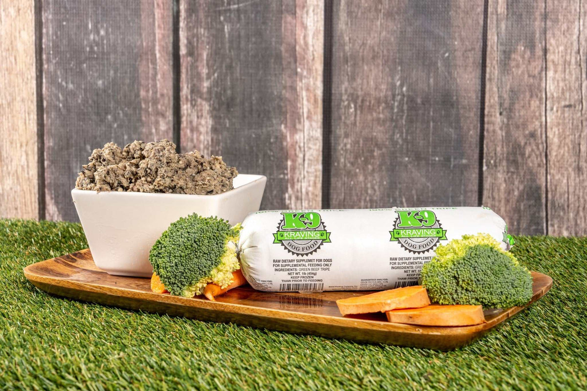 K-9 Kraving Green Tripe with fresh vegetables on a wooden tray.