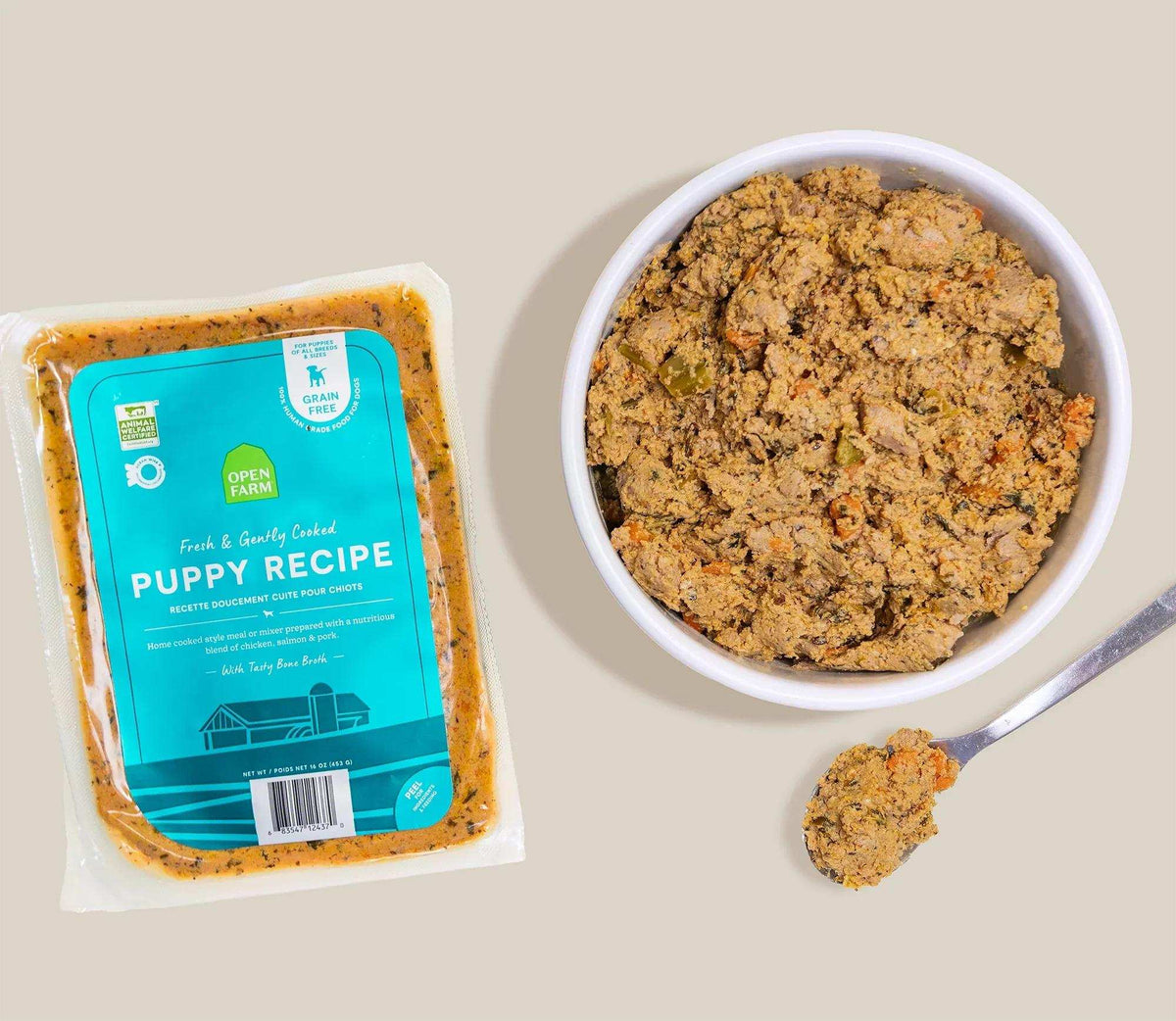Puppy Grain-Free gently cooked dog food, brown ground-texture recipe in a sealed turquoise-labeled package beside a bowl and spoon.