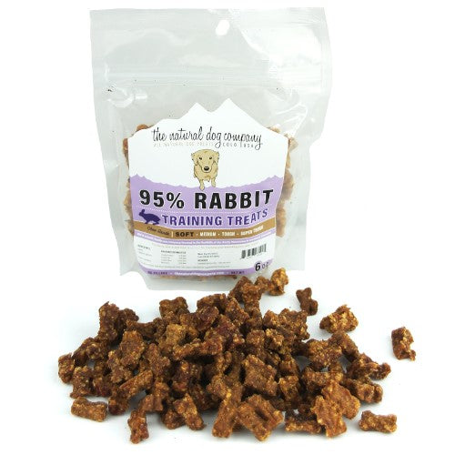 Rabbit Training Bites are small, brown, bone-shaped dog treats made from 95% rabbit meat in a clear resealable bag.