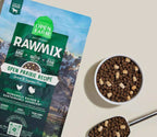 Grain-free dog kibble with brown nuggets and pale freeze-dried chunks, beside RawMix Open Prairie packaging.