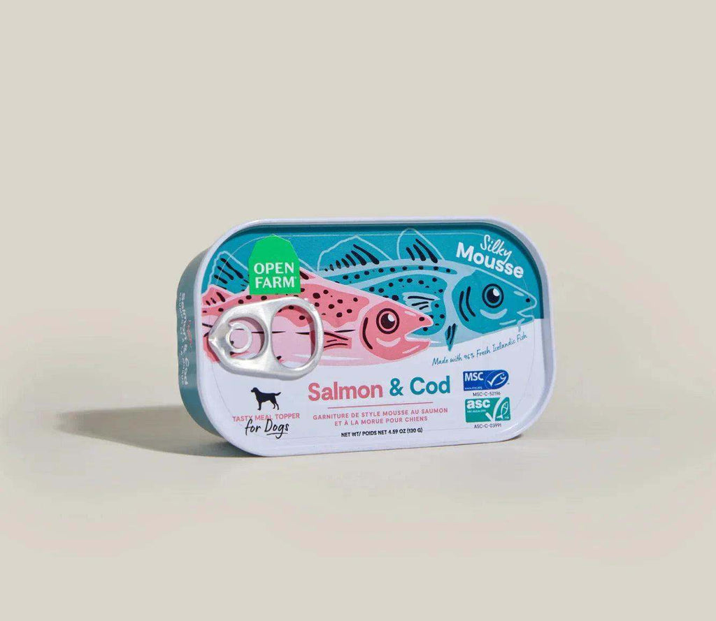 Rectangular metal tin of Salmon & Cod Topper for dogs with pink and blue fish illustrations and pull-tab lid