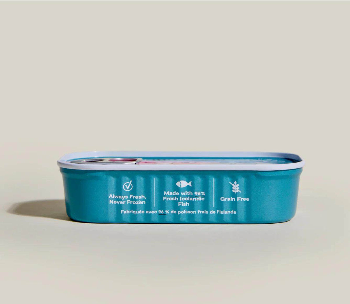 Salmon & Cod Topper in a teal metal tray with a silver rim and white freshness and grain-free labels.