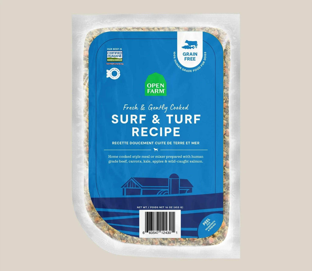 Dog food in a clear sealed pouch with a blue Surf & Turf Grain-Free label and visible mixed ingredients around the edges.