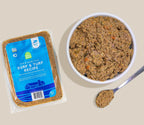 Fresh dog food with Surf & Turf Grain-Free recipe, tan-brown minced texture in a sealed blue-labeled pack and bowl.