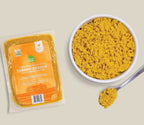 Tummy Rescue Dog Food in an orange sealed package beside a bowl of yellow-orange crumbled food and a spoonful.